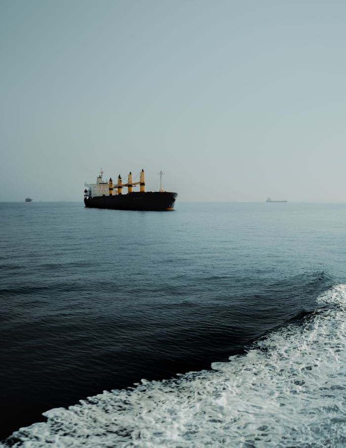Serene view of a cargo ship on calm sea waters, highlighting transportation.